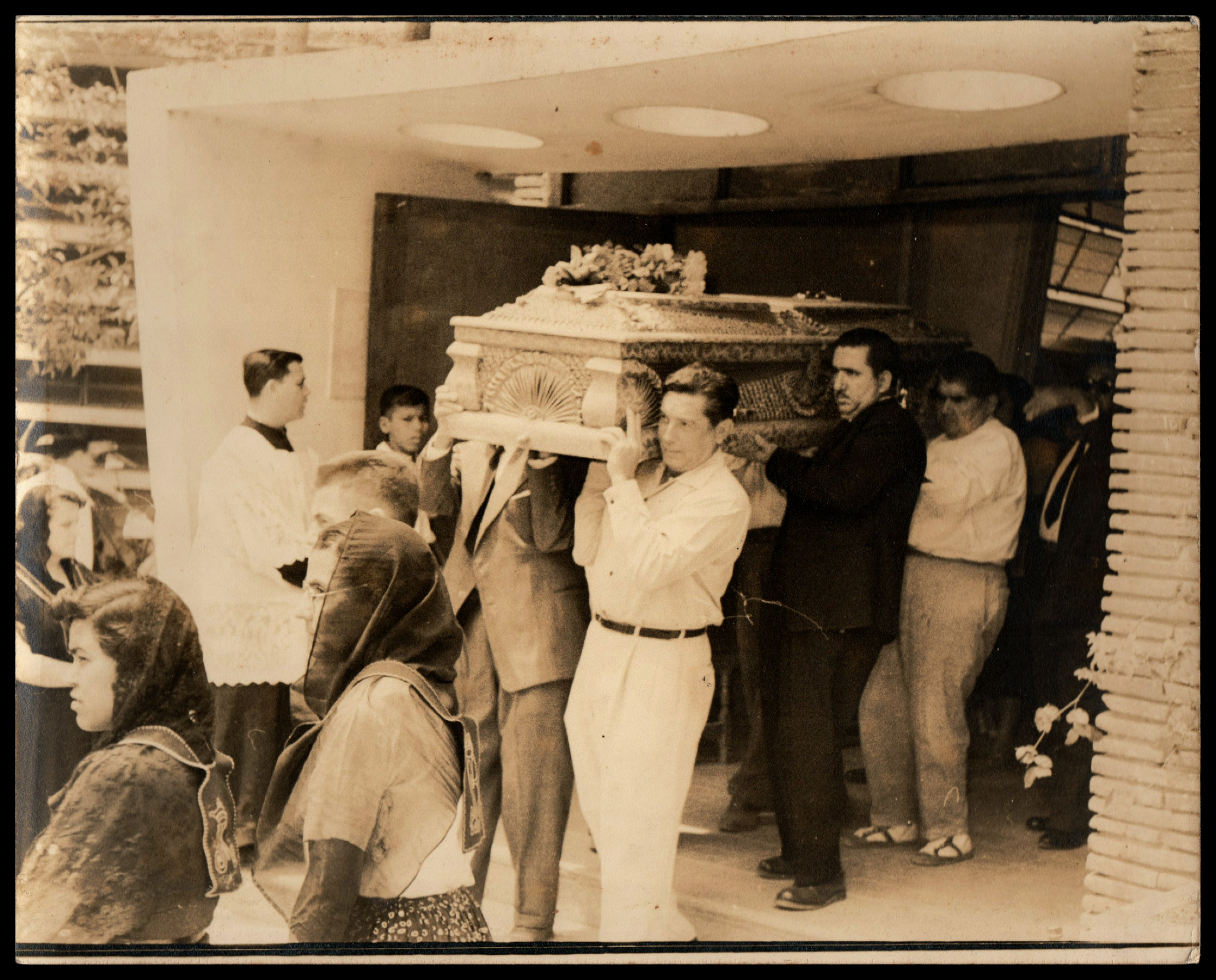 Sepia toned photograph depicting a funeral of an unknown deceased mourned by La Fraternidad de Nuestra Señora de Salve Regina (?). Obtained at the Mercado de Antigüedades de La Lagunilla. Two of a set of four.